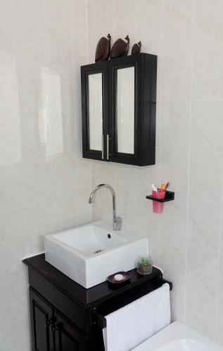 a bathroom with a white sink and a black cabinet at House 10-on-Sea in Hermanus