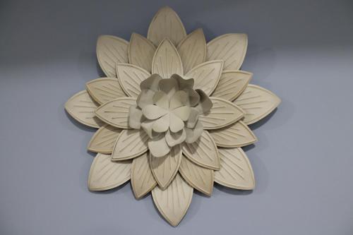un adorno floral de madera en una pared blanca en Apartamentos Turísticos ESCORRALADAS en Baltanás