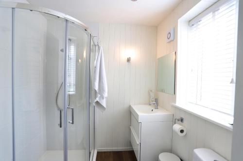 a bathroom with a shower and a toilet and a sink at Northumberland-Hideaways in Kielder