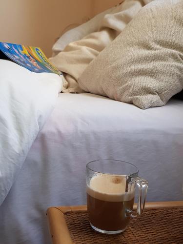 a cup of coffee on a tray next to a bed at THE POPPIES Guest House - 100m Ocean - Private Spaces in Candelaria