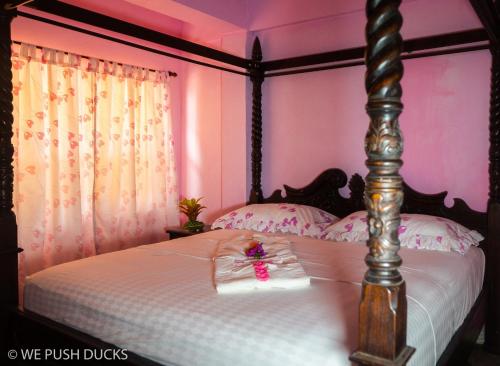 a bedroom with a bed with pink walls at Belle View Apartment Villa - La Mar penthouse in Laborie