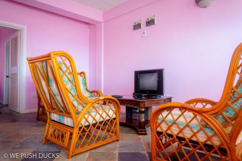 a living room with two chairs and a television at Belle View Apartment Villa - La Mar penthouse in Laborie