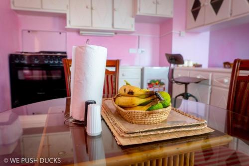 a basket of bananas on a table with a roll of paper towels at Belle View Apartment Villa - La Mar penthouse in Laborie