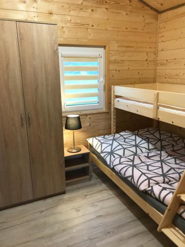 a bedroom with two bunk beds and a window at Domki u Iwony#sauna#balia in Kudowa-Zdrój