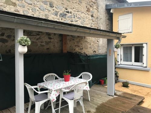 une table et des chaises assises sur une terrasse en bois dans l'établissement Petite maison proche du centre ville, à Cauterets