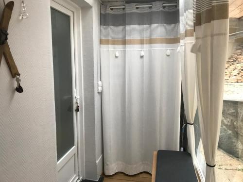 un rideau de douche blanc posé à côté d'une porte dans l'établissement Petite maison proche du centre ville, à Cauterets