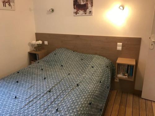- une chambre avec un lit doté d'une tête de lit en bois dans l'établissement Petite maison proche du centre ville, à Cauterets