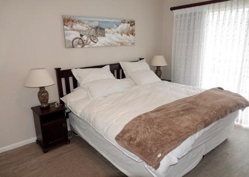 a bedroom with a large bed with white sheets and pillows at House 10-on-Sea in Hermanus