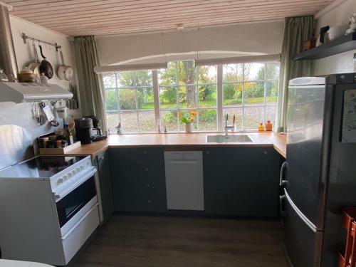 a kitchen with a sink and a window at Hegnsly in Odder