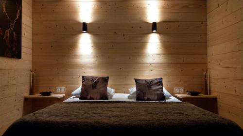 a bedroom with a bed with wooden walls and lights at Domaine de l'Olifant in Champanges