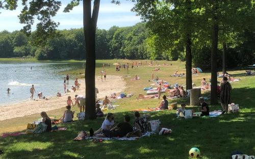 a group of people sitting on the grass at a beach at Vakantieverhuur Bienvenue in Boyl