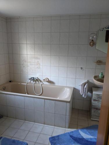 a white bathroom with a tub and a sink at Ferienwohnung Lücking im Westerwald in Flammersfeld