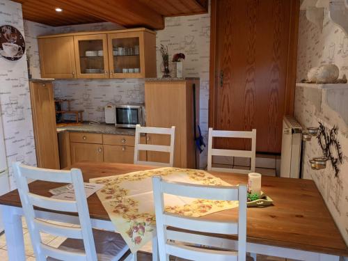 a kitchen with a wooden table and chairs at Ferienwohnung Lücking im Westerwald in Flammersfeld
