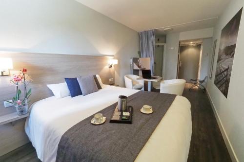 um quarto de hotel com uma cama grande com uma bandeja em The Originals Access, Hôtel Millau Sud (P'tit Dej-Hotel) em LʼHospitalet-du-Larzac