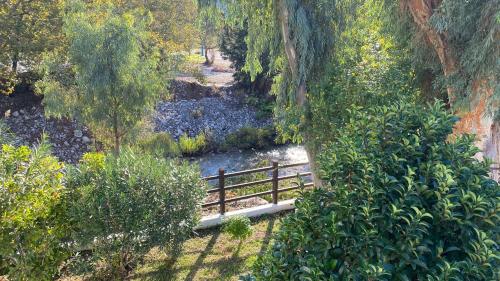 a wooden fence next to a river with a bridge at Blumenhaus (Spiti Louloudia) in Paralía Sergoúlas