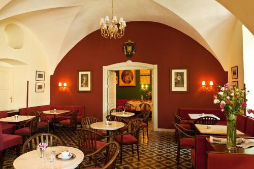 a restaurant with red walls and tables and chairs at Austrian Pilgrim Hospice in Jerusalem