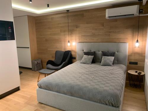 a bedroom with a large bed and a chair at LUXURIOUS ONE BEDROOM STUDIO IN TOP CENTER in Blagoevgrad