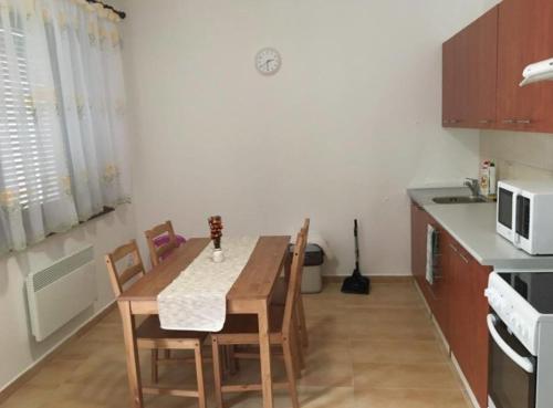 a kitchen with a table and chairs and a microwave at Penzion Lea v Patinciach in Patince