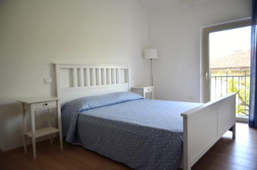 a white bedroom with a bed and a window at Petit Hotel in Lido di Camaiore