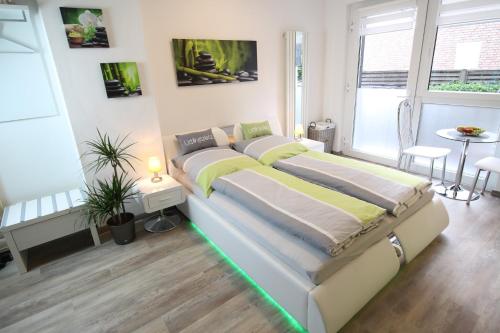um quarto com uma cama grande e iluminação verde em Wellnessapartment em Oberhausen