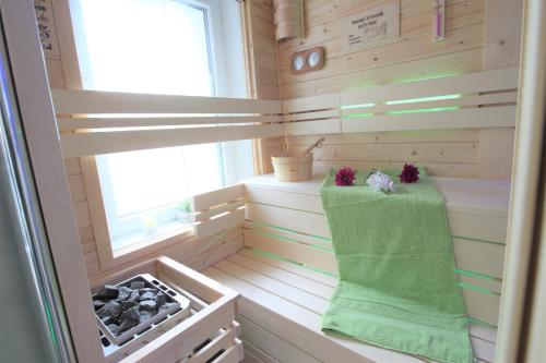 a sauna with a green towel and a window at Wellnessapartment in Oberhausen