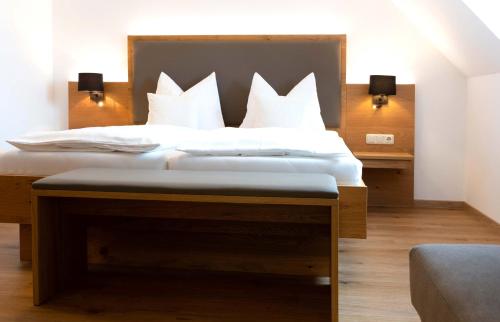 Au in der HallertauにあるHotel Gasthof Rosenwirtの白い枕が付いた大きなベッドのある寝室