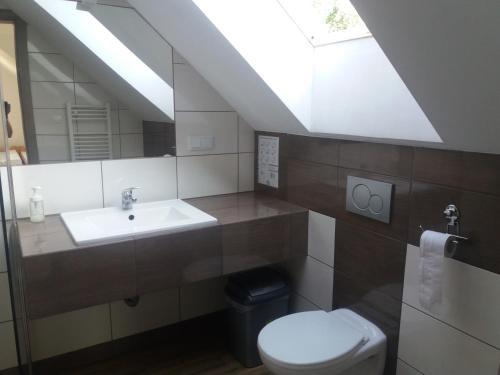 a bathroom with a sink and a toilet at Noclegi Pod Dębem in Skawina