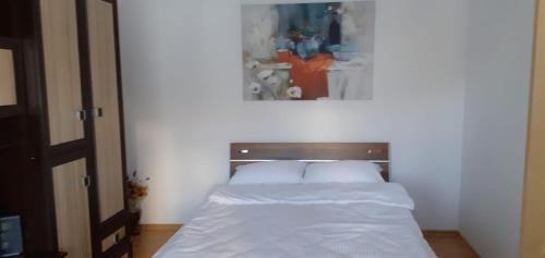 a bed with white sheets and pillows in a bedroom at Urban Chic Apartment in Orăştie