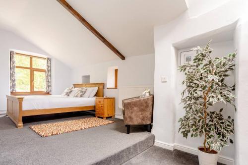 1 dormitorio con 1 cama, 1 silla y 1 ventana en Delightful 2 bed flat in Old Mill-private garden, en Keighley