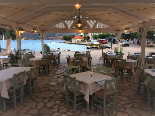 a restaurant with tables and chairs with a view of the water at Blumenhaus (Spiti Louloudia) in Paralía Sergoúlas