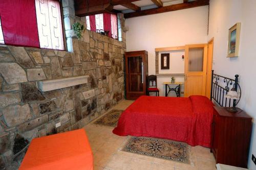 a bedroom with a red bed and a stone wall at Bibc Wine & Holiday in Trieste