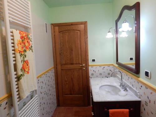a bathroom with a sink and a wooden door at Oliveto Cottage in Capannori