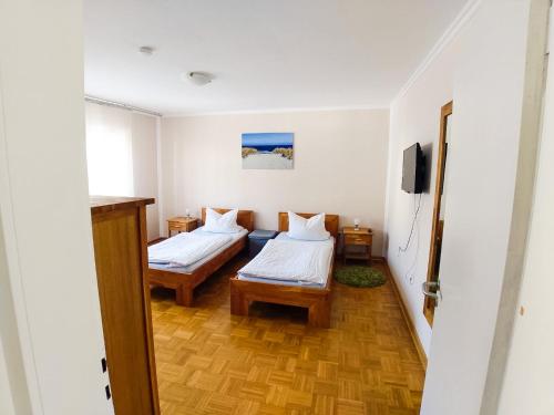 a small room with two beds and a television at Modern Apartment Wissenbach 1 in Eschenburg