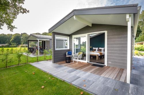 a small house with a deck with a table at Grenzeloos in Doldersum