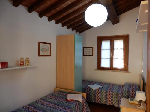 a bedroom with two beds and a window at Oliveto Cottage in Capannori