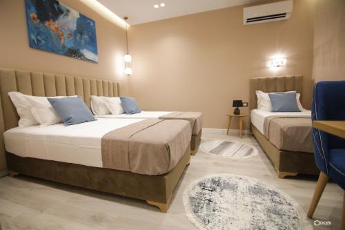 1 Schlafzimmer mit 2 Betten und einem blauen Stuhl in der Unterkunft Vila Livi in Korçë