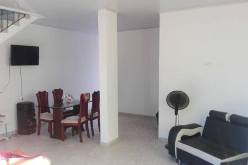 a living room with a couch and a table with chairs at Casa en conjunto campestre, rana y bolirrana incluido. in Apulo