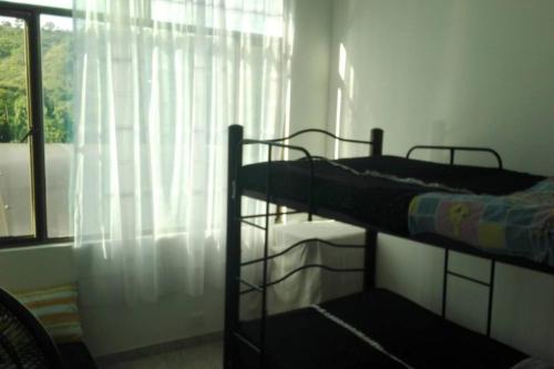 two bunk beds in a room with a window at Casa en conjunto campestre, rana y bolirrana incluido. in Apulo
