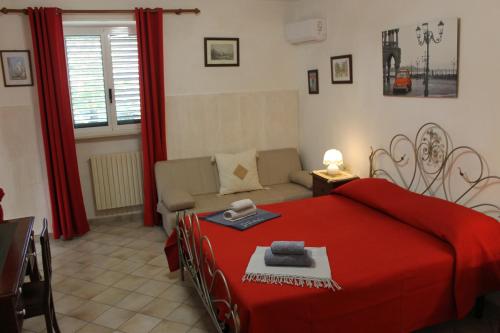 チェーリエ・メッサーピカにあるDimora Villa Mariaのリビングルーム(赤いベッド1台、ソファ付)