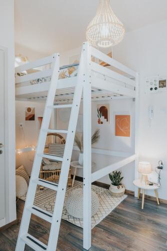 a white bunk bed with a ladder in a room at Bohemian Loft With View! in Volos