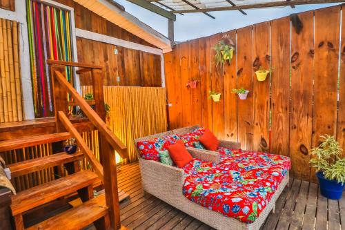 porche con sofá y pared de madera en La Gloria House, en Ilhabela