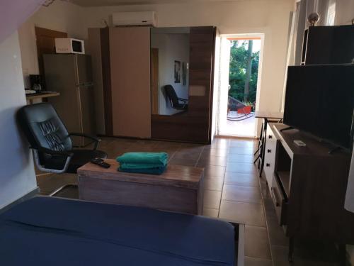 een woonkamer met een bank, een stoel en een televisie bij la maison du nord in Acoua