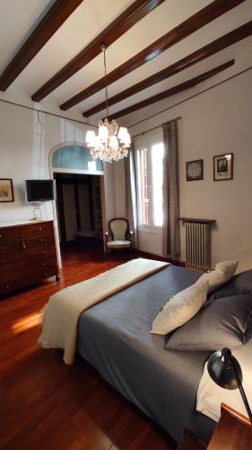 Un dormitorio con una cama grande y una lámpara de araña. en Casa MO, en Sabadell