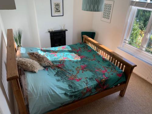 een slaapkamer met een bed met een blauw dekbed bij White Heather Terrace in Bovey Tracey