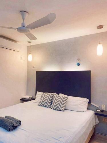 1 dormitorio con 1 cama blanca grande y cabecero azul en Casa Sol Y Luna Luxury Valladolid Yucatán en Valladolid