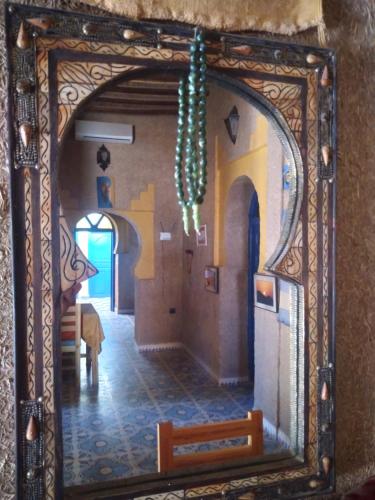 a mirror reflecting a dining room with a table at Maison Mirage B&B in Hassilabied