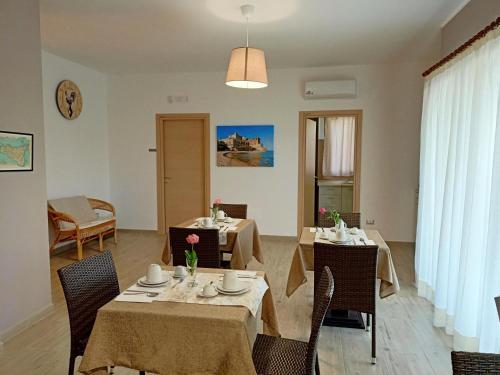 een eetkamer met 2 tafels en stoelen bij B&B Villa Sara Falconara in Licata