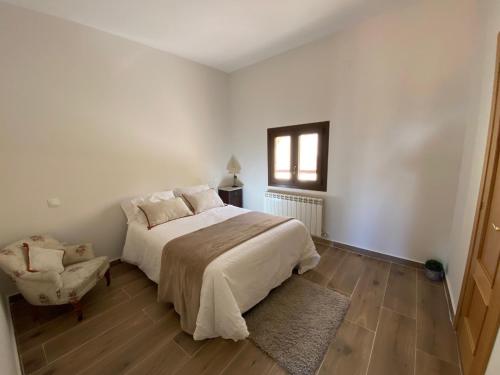 a white bedroom with a bed and a window at SILBO RURAL in Borox