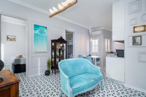 a blue chair in a room with a kitchen at Heritage House Leiria in Leiria