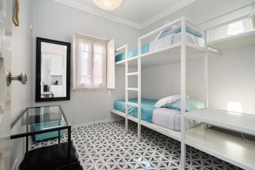 een slaapkamer met een wit stapelbed en een spiegel bij Heritage House Leiria in Leiria